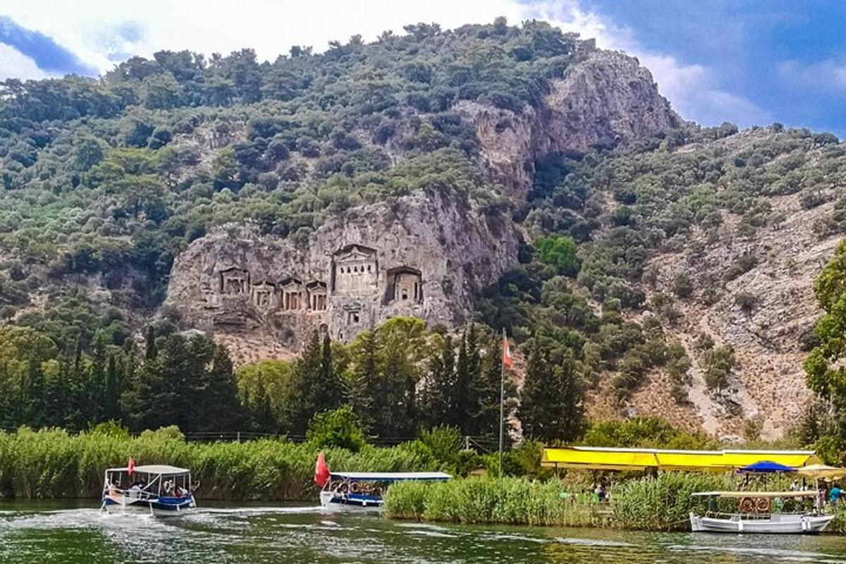 un edifici al vessant d'una muntanya amb vaixells a l'aigua