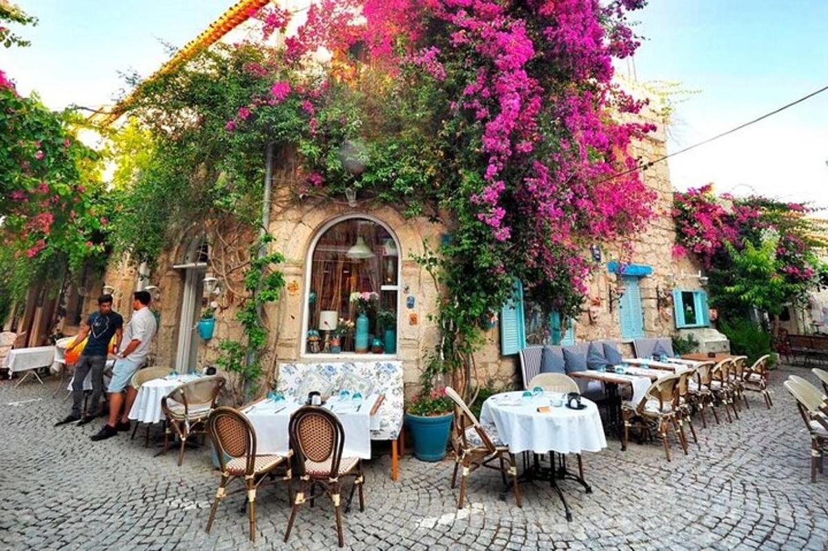 restaurace se stoly a květinami před budovou
