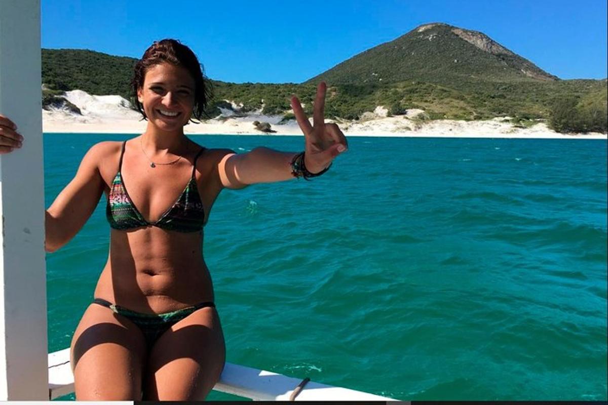 una donna in bikini in piedi su una barca in acqua