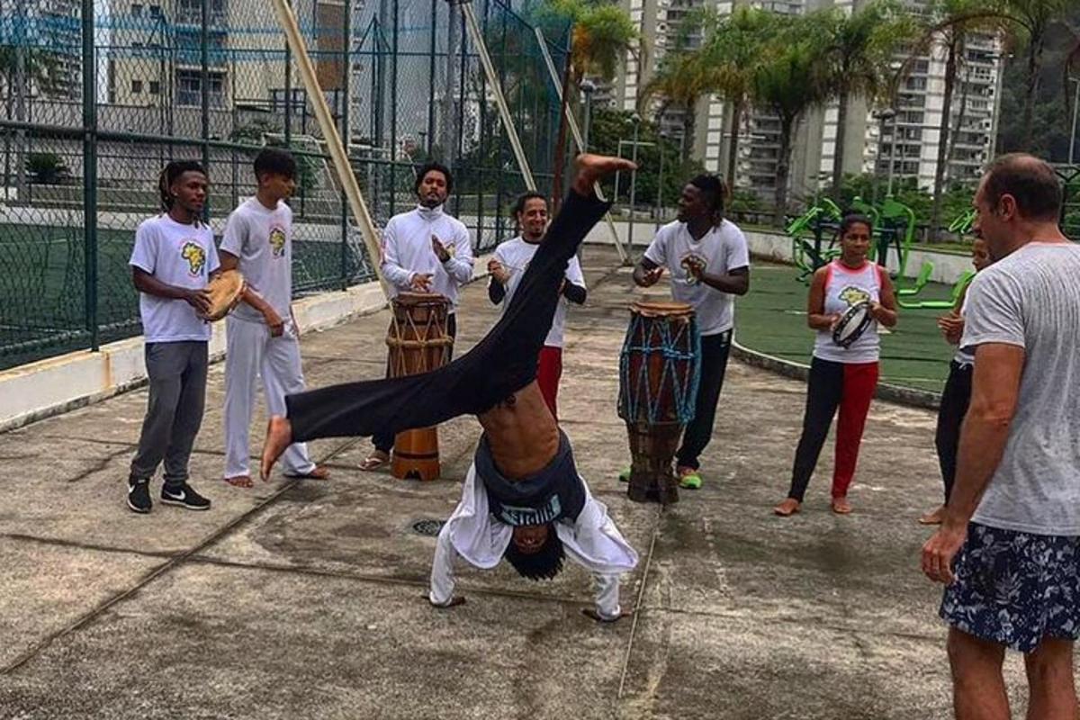 Ein Mann macht vor einer Gruppe von Menschen einen Handstand