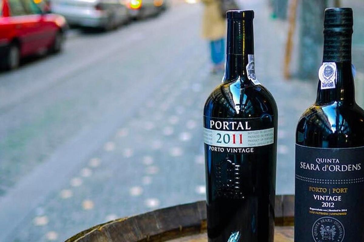 două sticle de vin așezate deasupra unui butoi