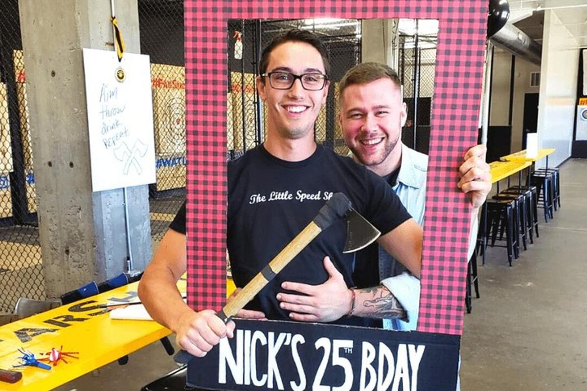 a man holding a sign with a baseball bat