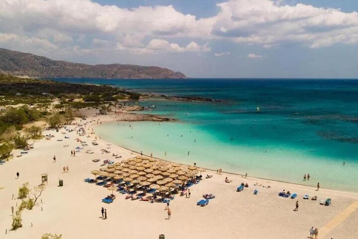 μια παραλία με ομπρέλες και ανθρώπους στο νερό