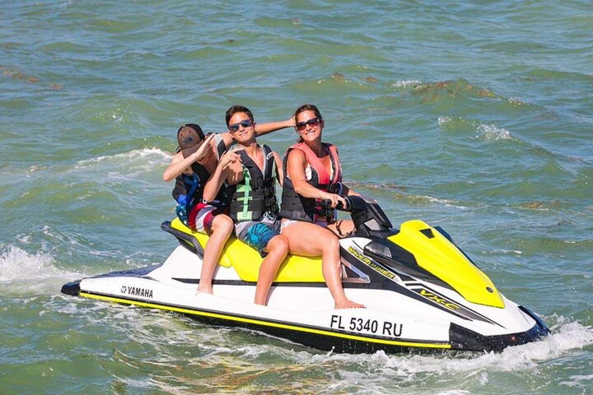 eine Gruppe von Menschen, die auf einem Jetski im Wasser fahren