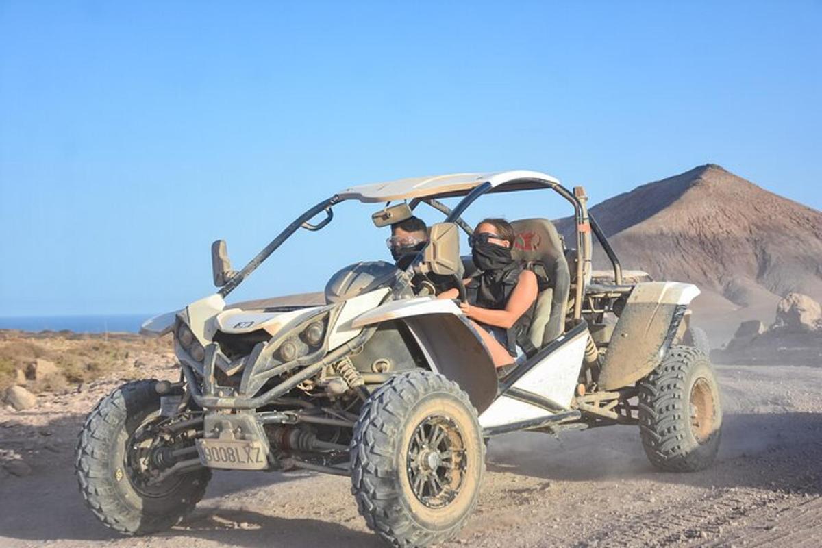 two people riding in an atv in the desert