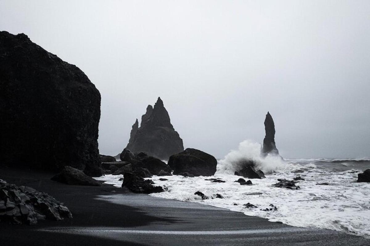 una foto in bianco e nero di una spiaggia con rocce e onde