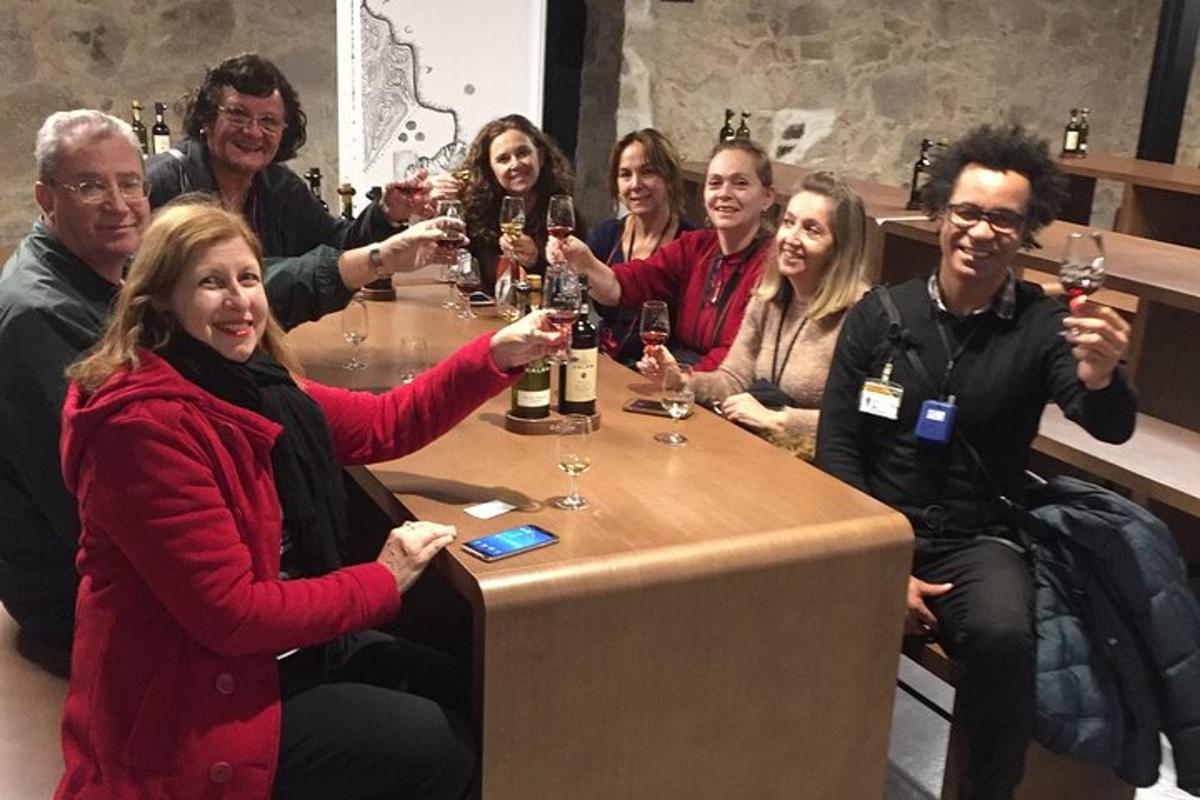 un gruppo di persone sedute attorno a un tavolo che bevono vino