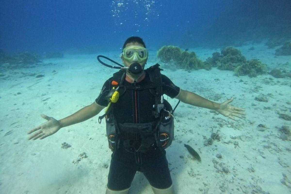 Un hombre con una máscara de buceo está parado en el océano.