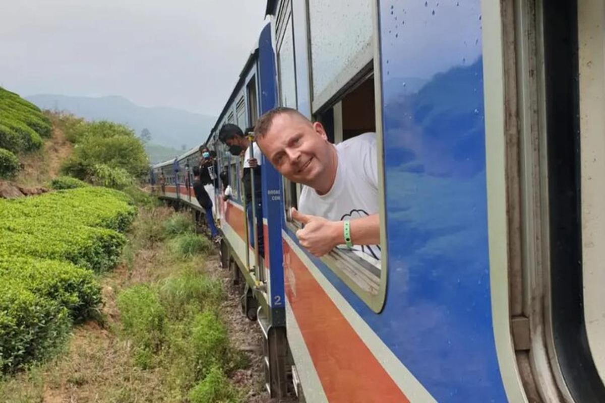 un home mirant per la finestra d'un tren blau