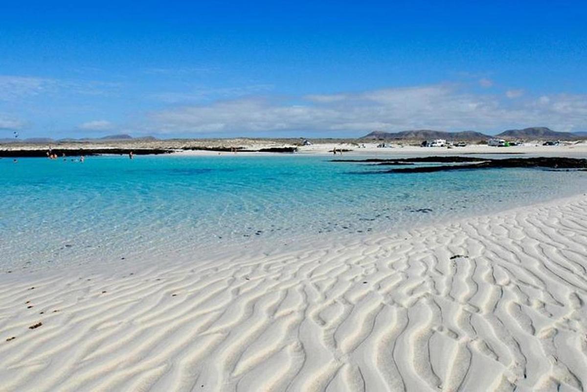 ein Strand mit blauem Wasser und weißem Sand