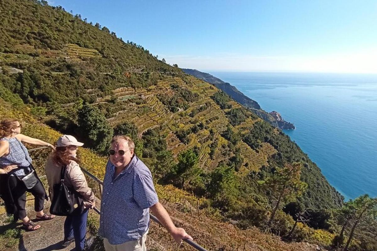 Un grupo de personas caminando por una colina cerca del océano.