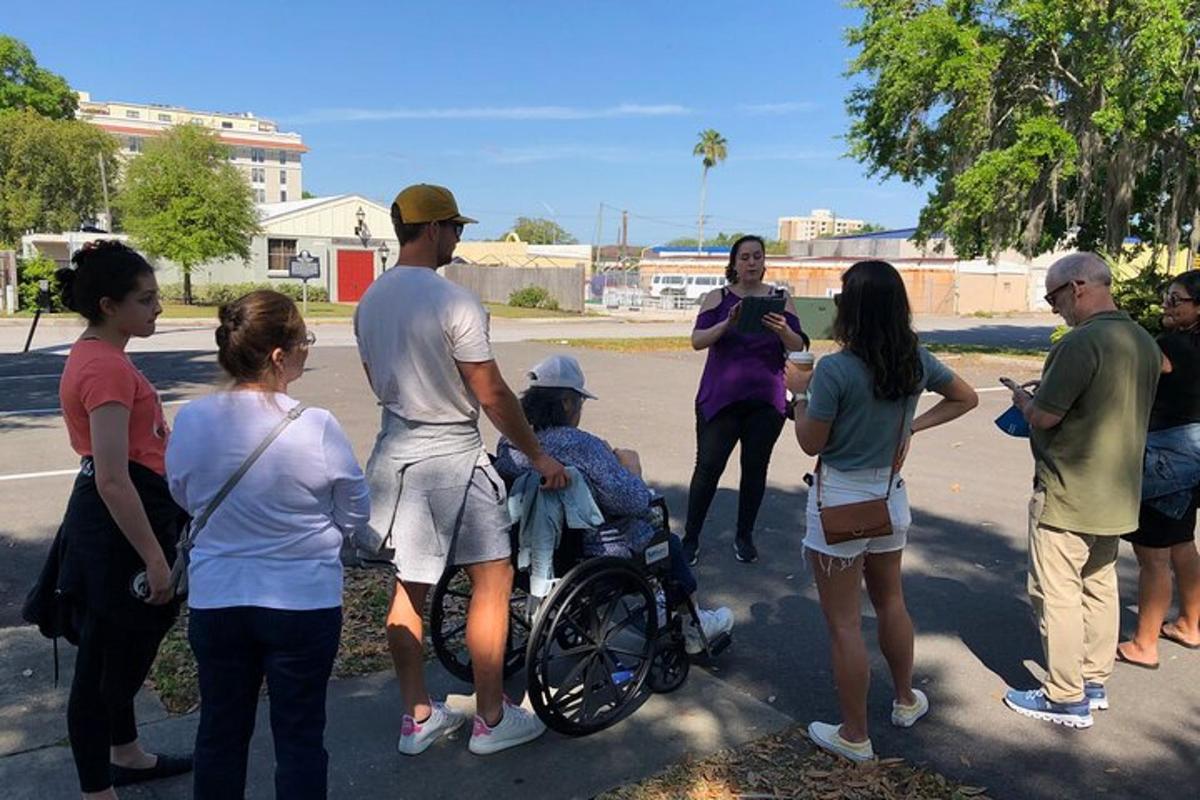 Un grupo de personas de pie alrededor de un hombre en silla de ruedas.