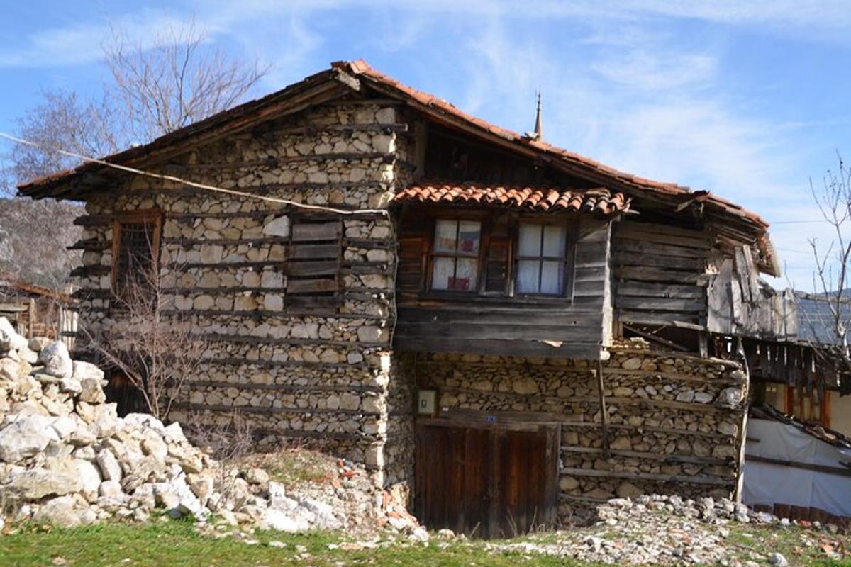 una antiga casa de pedra amb una finestra a un turó