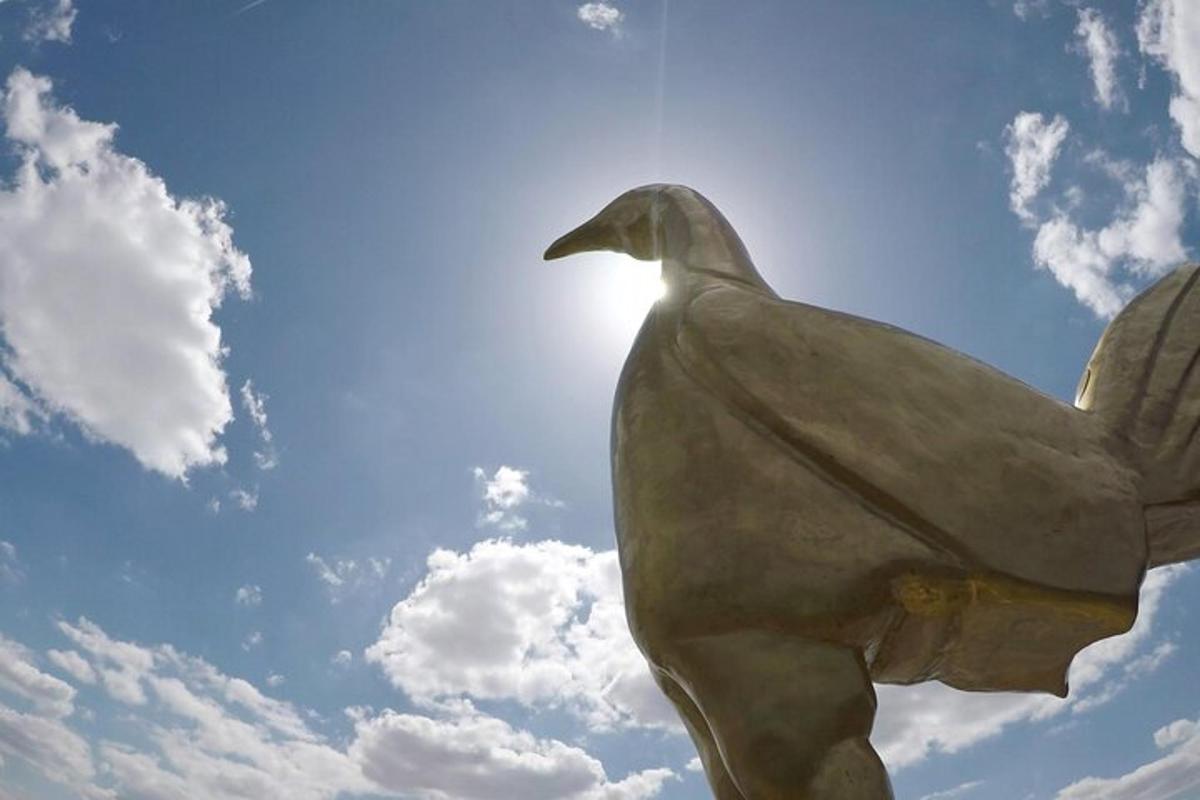 uma estátua de um pato em frente ao céu
