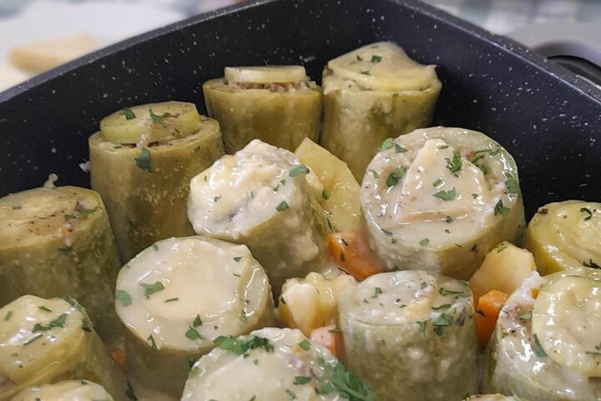uma panela cheia de batatas com queijo e vegetais