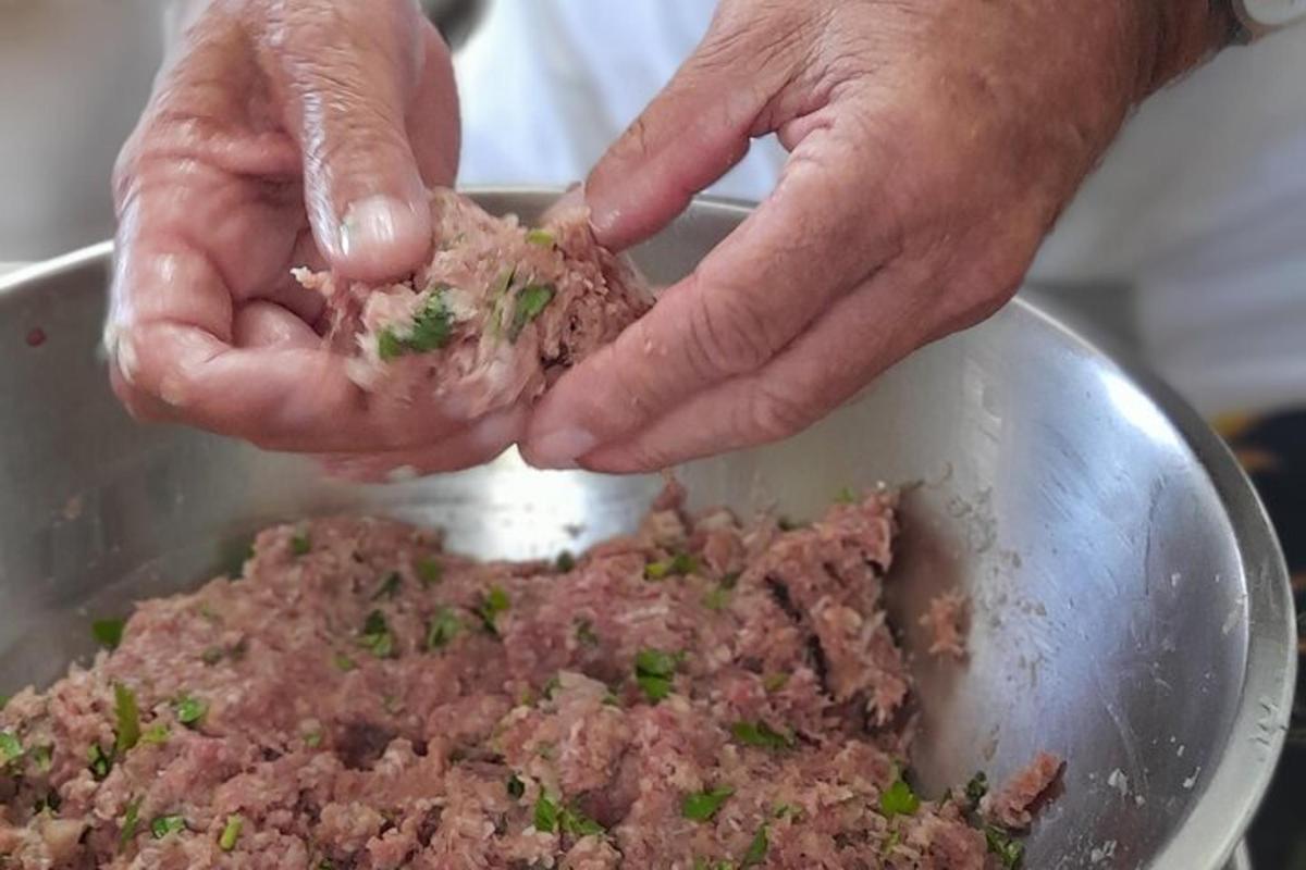 uma pessoa segurando um pedaço de carne em uma tigela