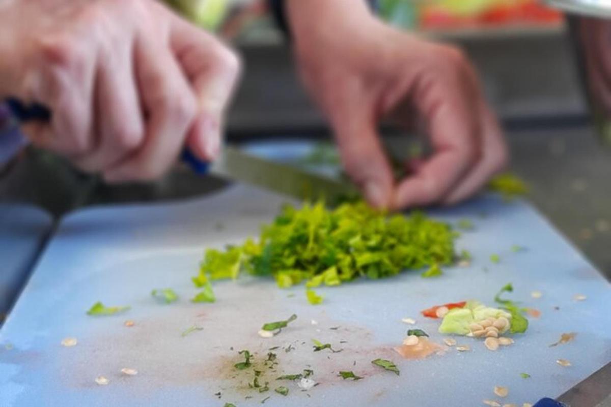uma pessoa cortando vegetais verdes em uma tábua de corte