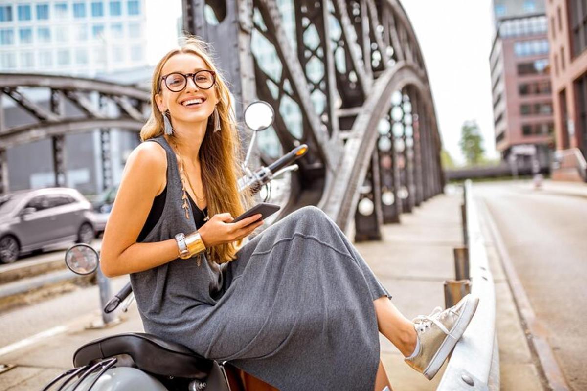 en kvinne som sitter på en scooter på en bro