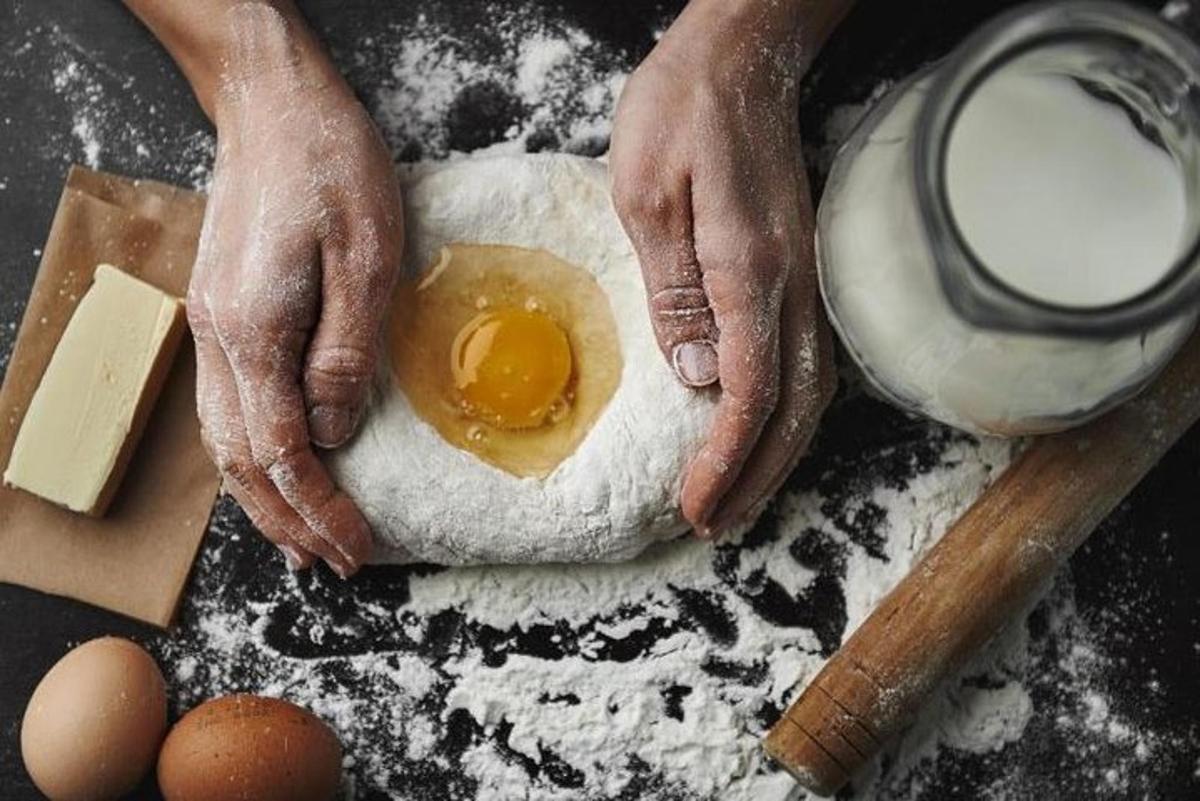 a person making a dough with an egg on top