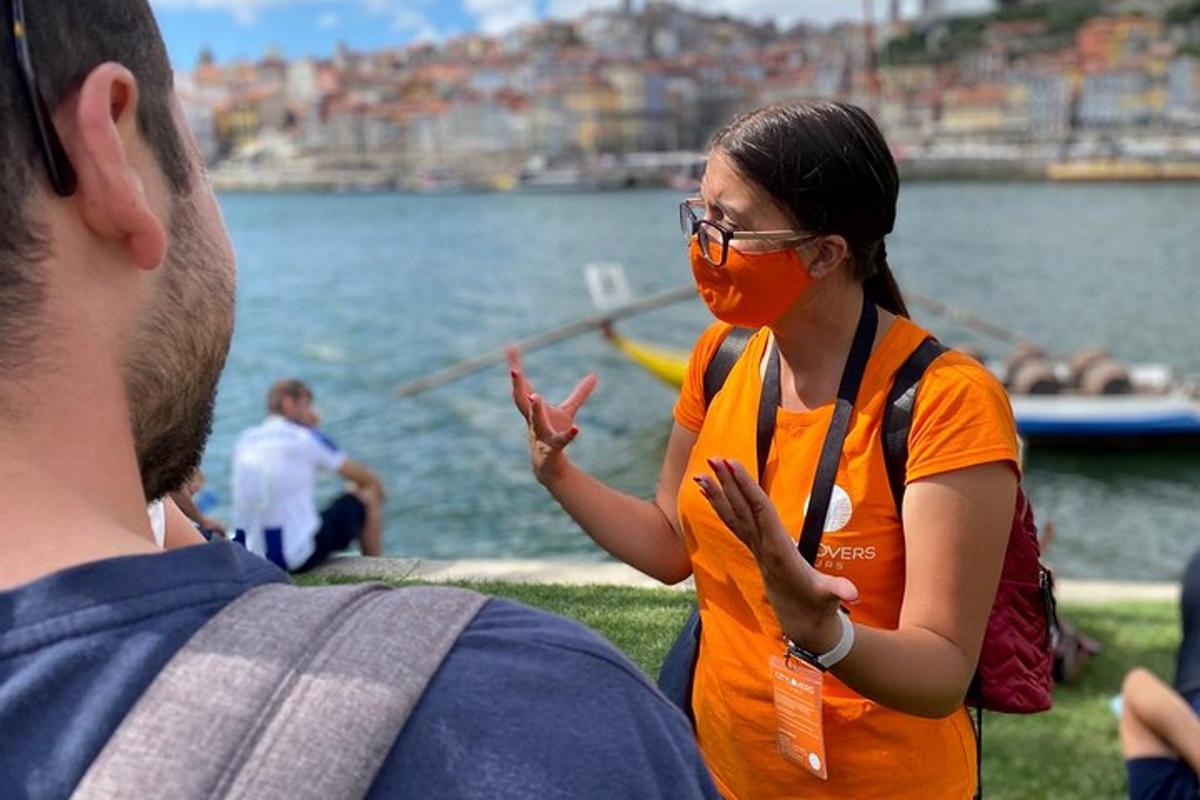 Egy narancssárga arcmaszkos nő áll a víz közelében