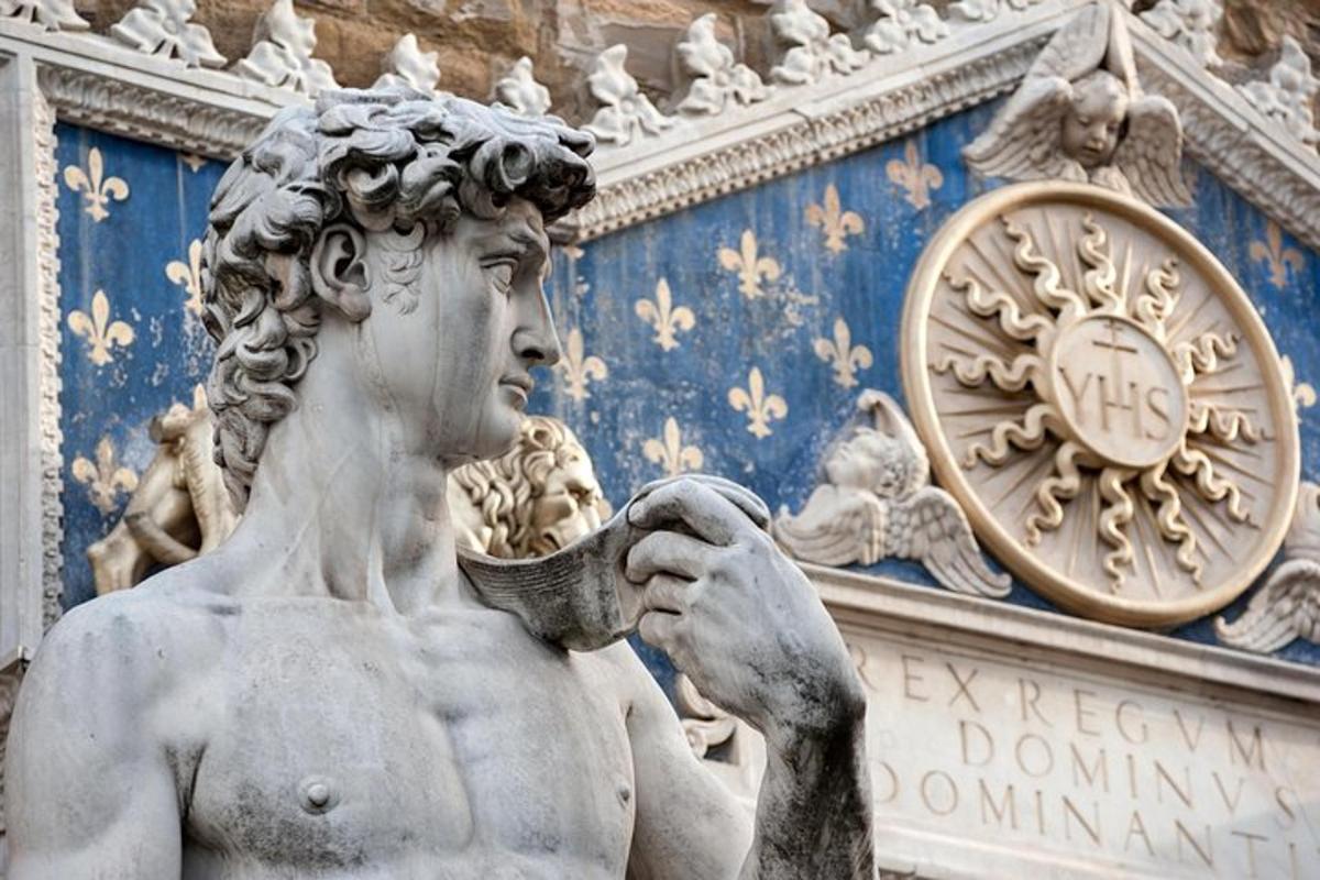 una statua di fronte a un edificio con un orologio