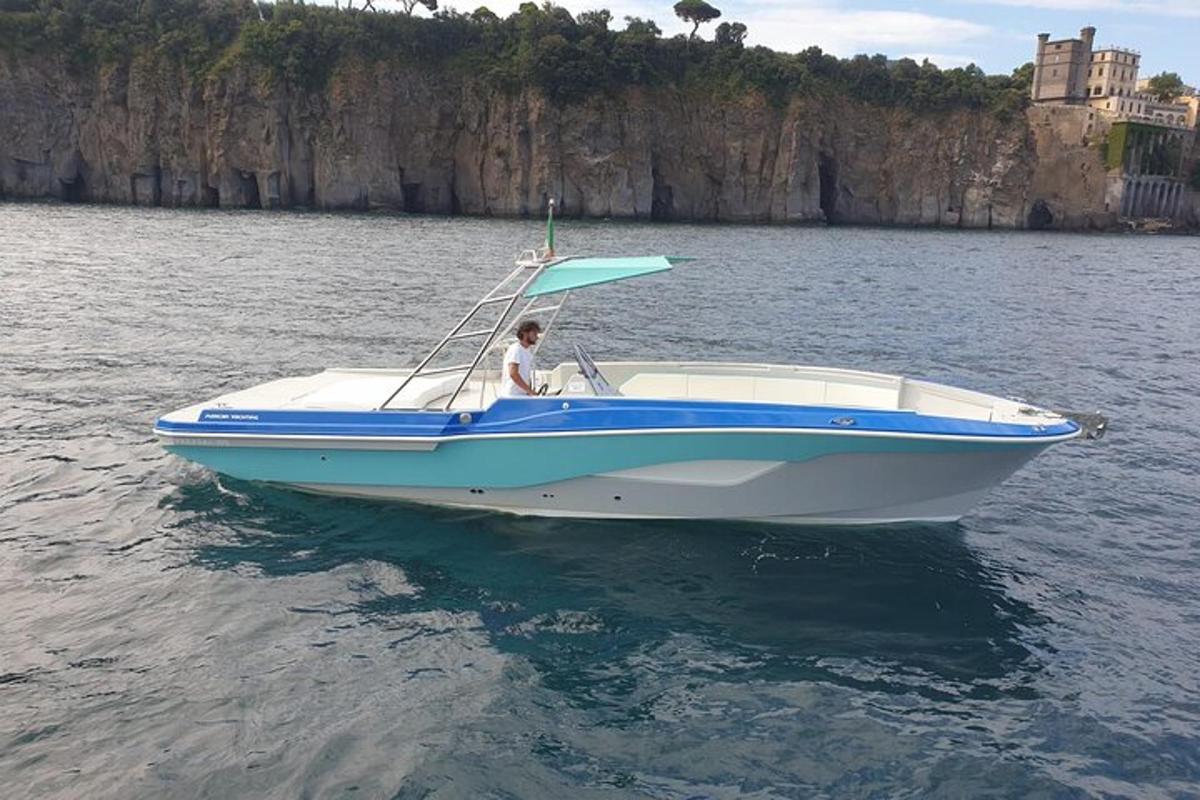 un uomo su una barca blu e bianca sull'acqua