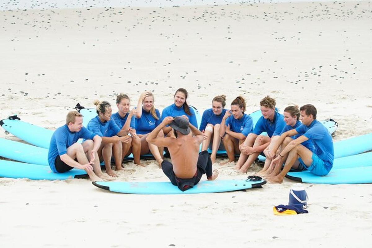 a group of people sitting on surfboards on the beach