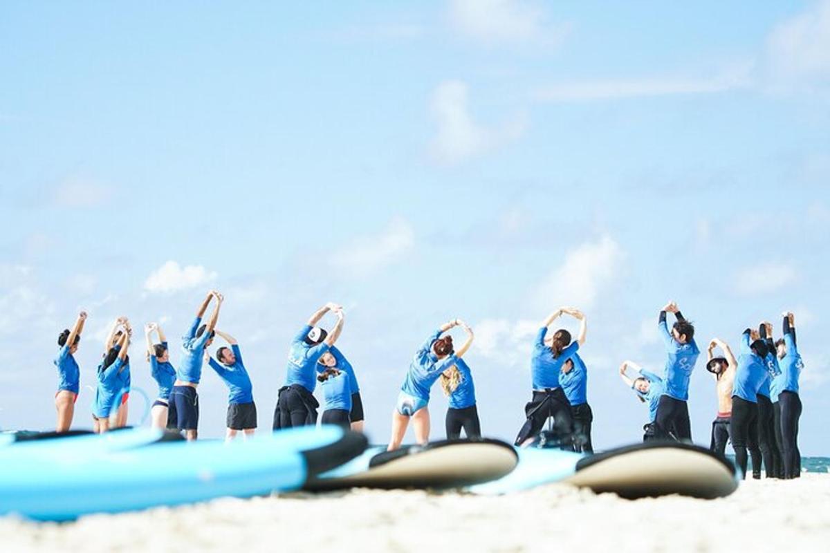a group of people standing on the beach with surfboards