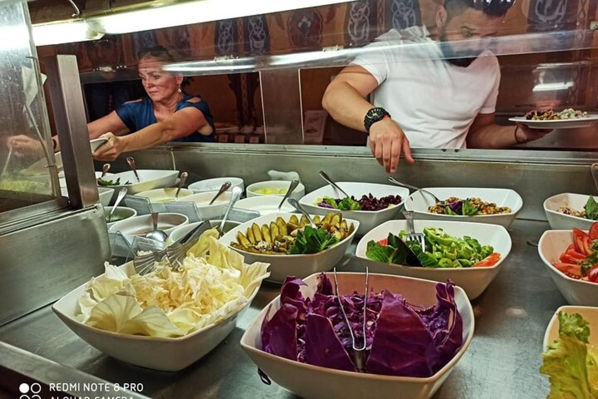 una linea di buffet con ciotole di diversi tipi di verdure