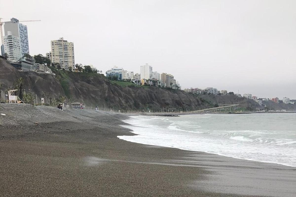 una platja amb edificis al fons i l'oceà