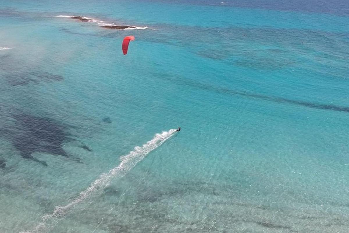 uma pessoa está empinando uma pipa no oceano