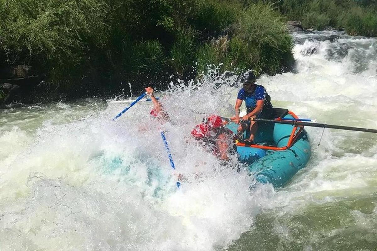 two people are on a raft in a river