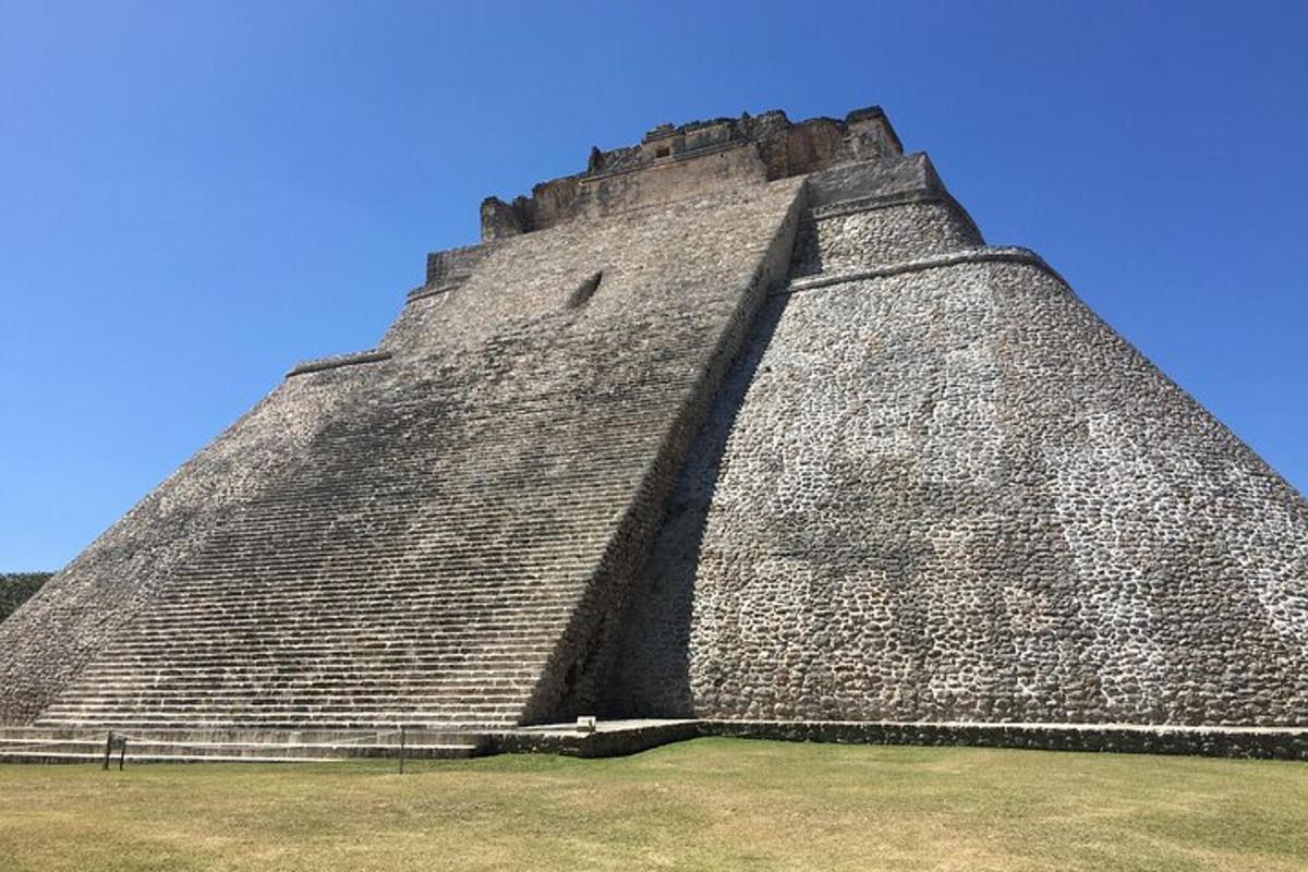 uma grande pirâmide com um céu azul atrás dela