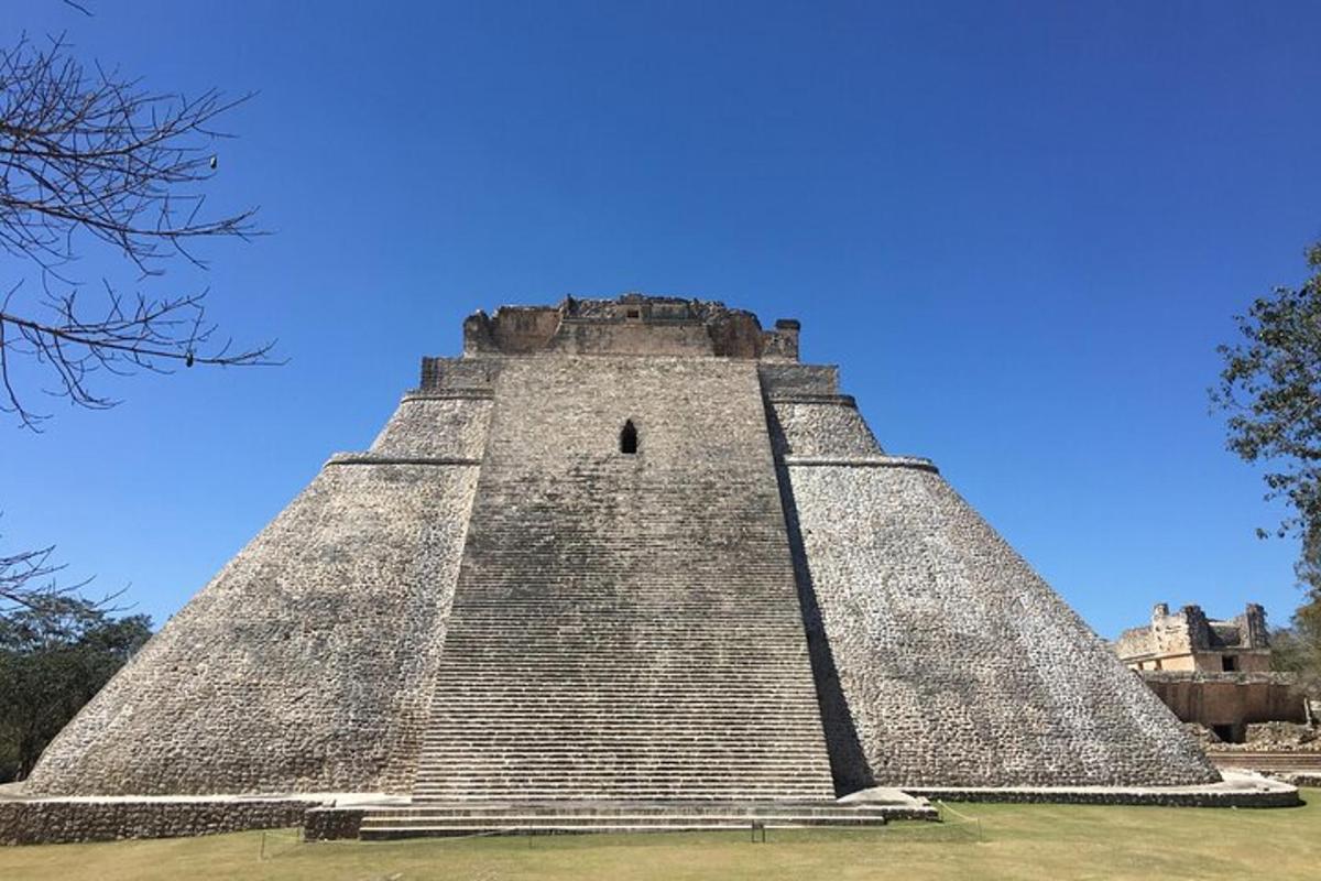 uma construção piramidal com um céu azul ao fundo