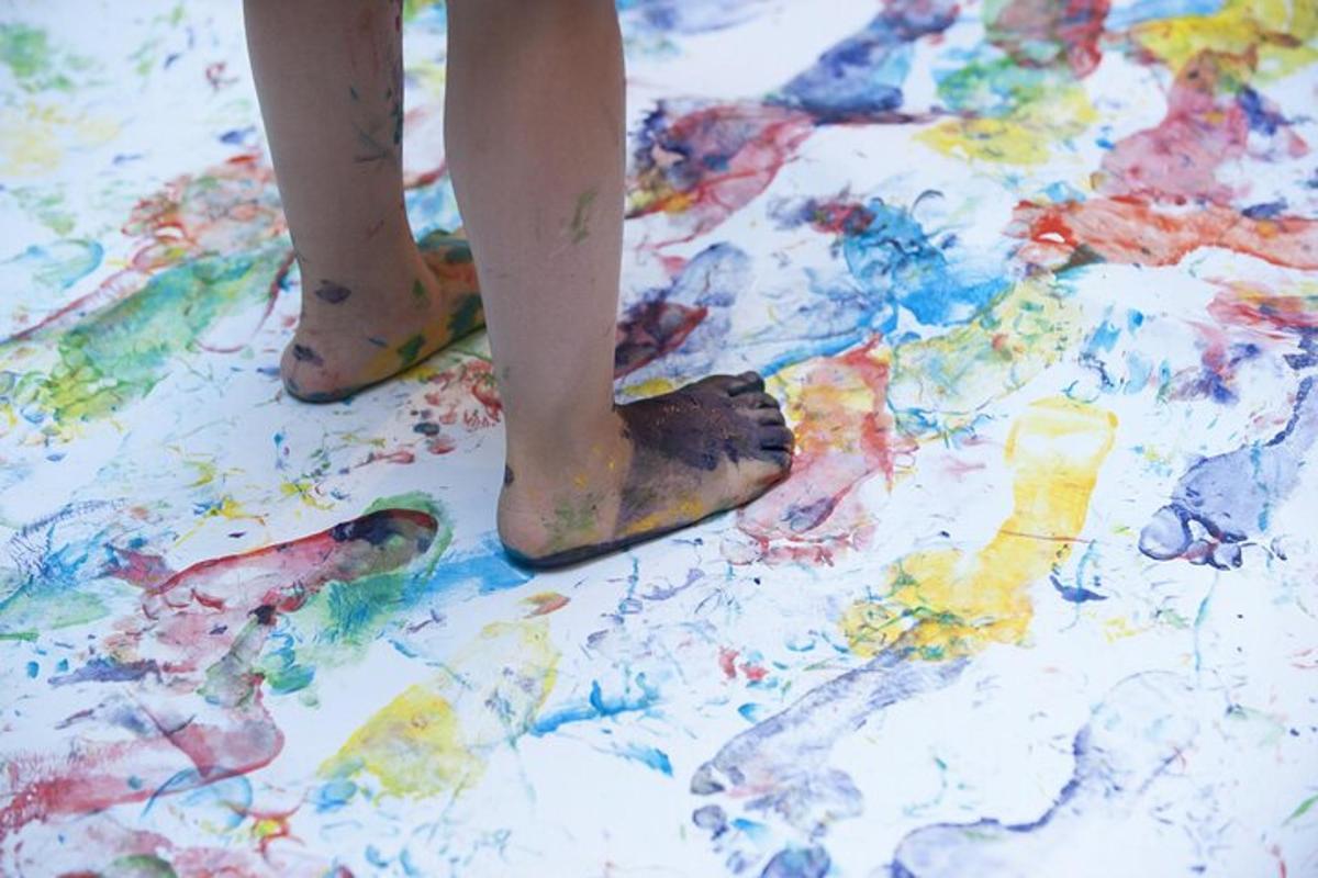 eine Person in Schuhen, die auf einem mit Farbe bedeckten Boden steht