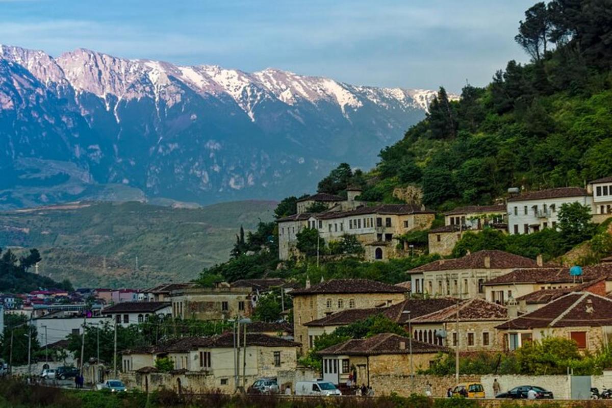 un pueblo en una colina con montañas al fondo
