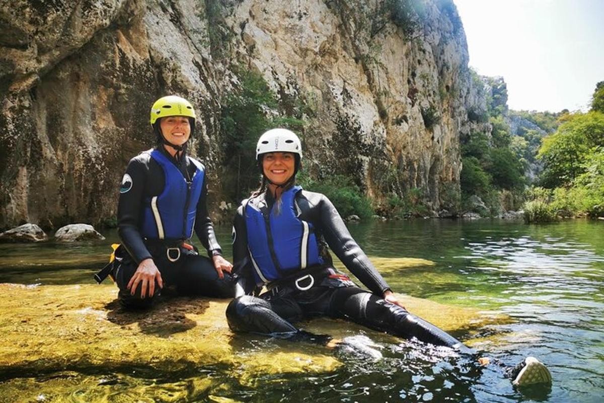 dues persones assegudes a l'aigua d'un riu