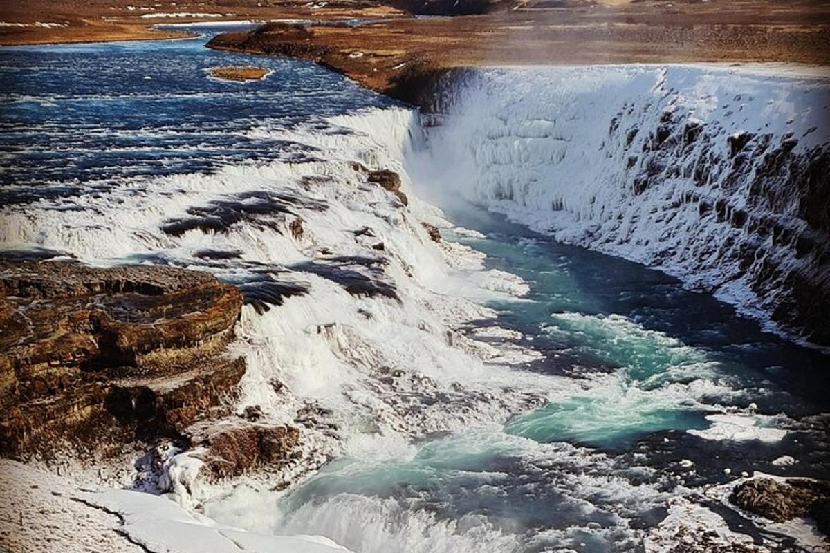 air terjun dengan salji di tepi sungai