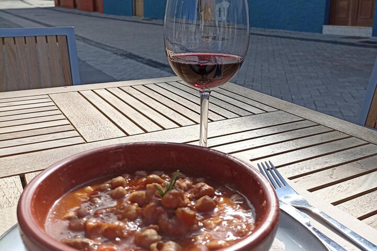 a bowl of food next to a glass of wine