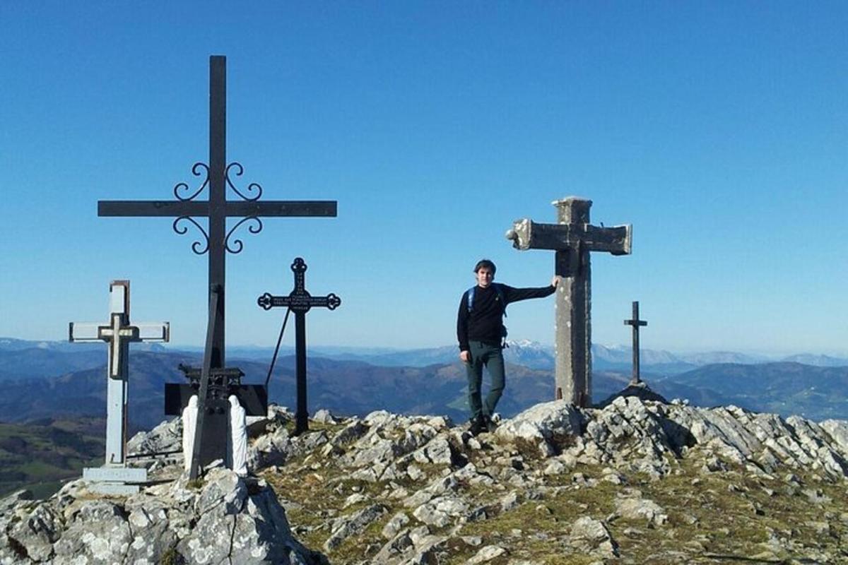 muž stojící na vrcholu hory s kříži