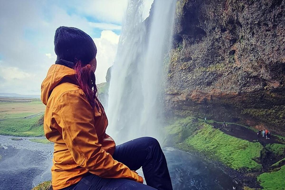 una dona asseguda davant d'una cascada