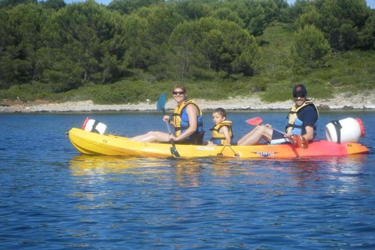 three people in a yellow kayak on the water