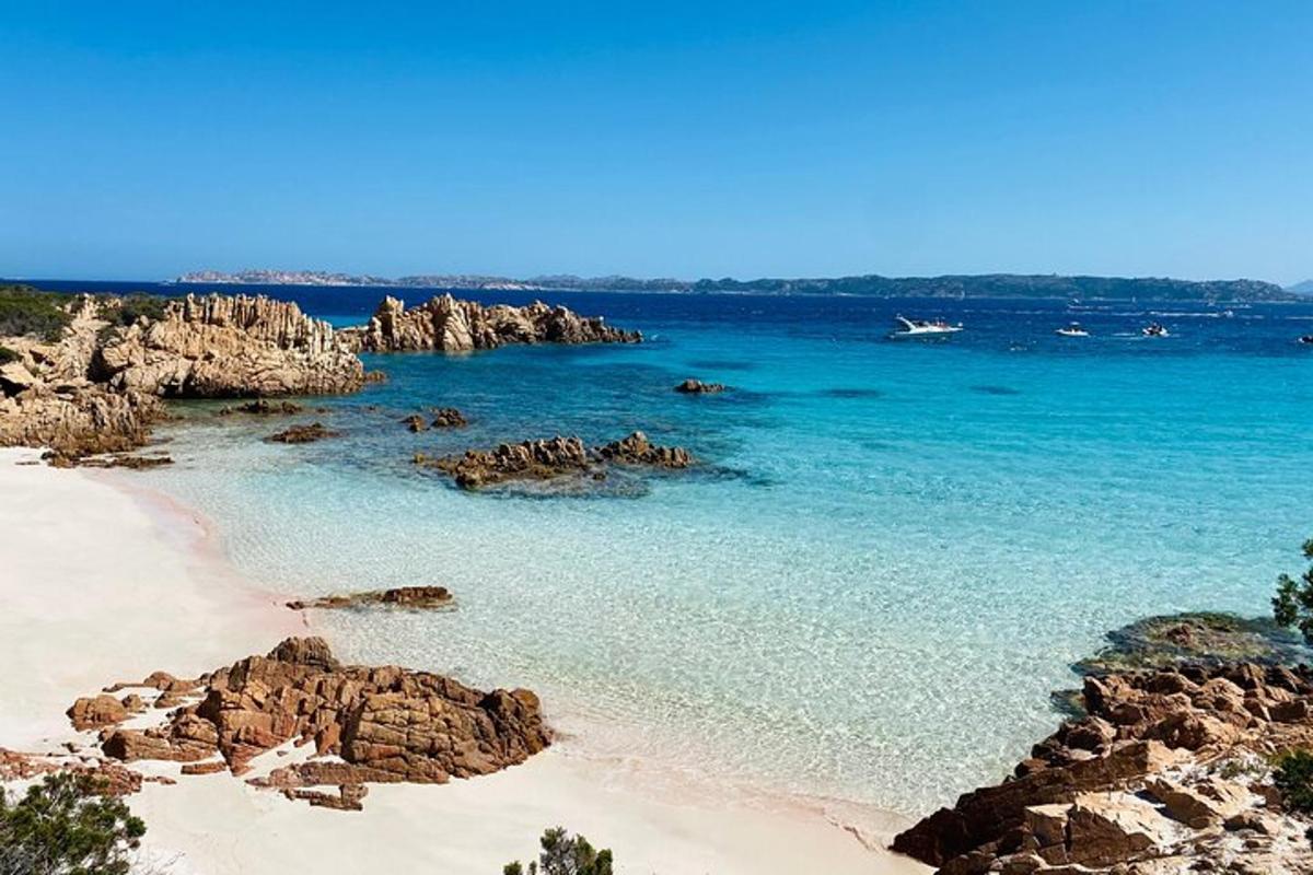 una platja amb roques i l'oceà amb un avió