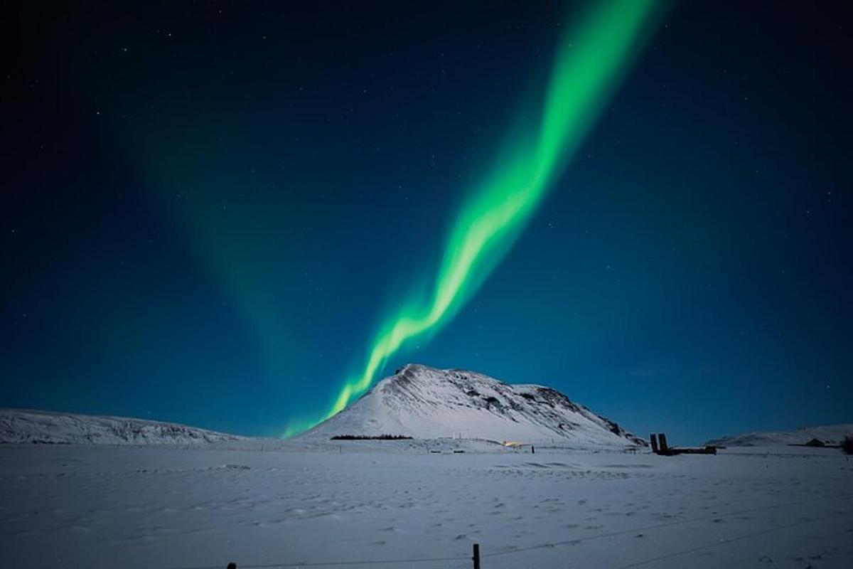 una luz verde en el cielo sobre una montaña