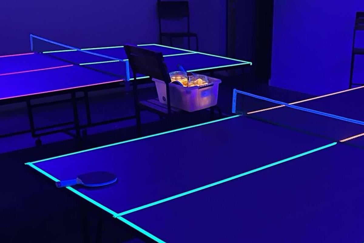 a ping pong table in a room with purple lights