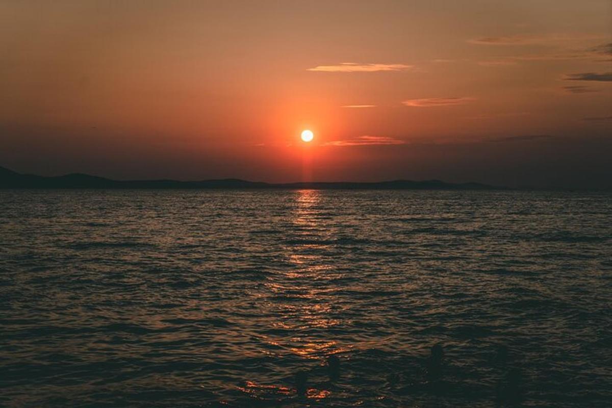 un tramonto sull'oceano con il sole che tramonta