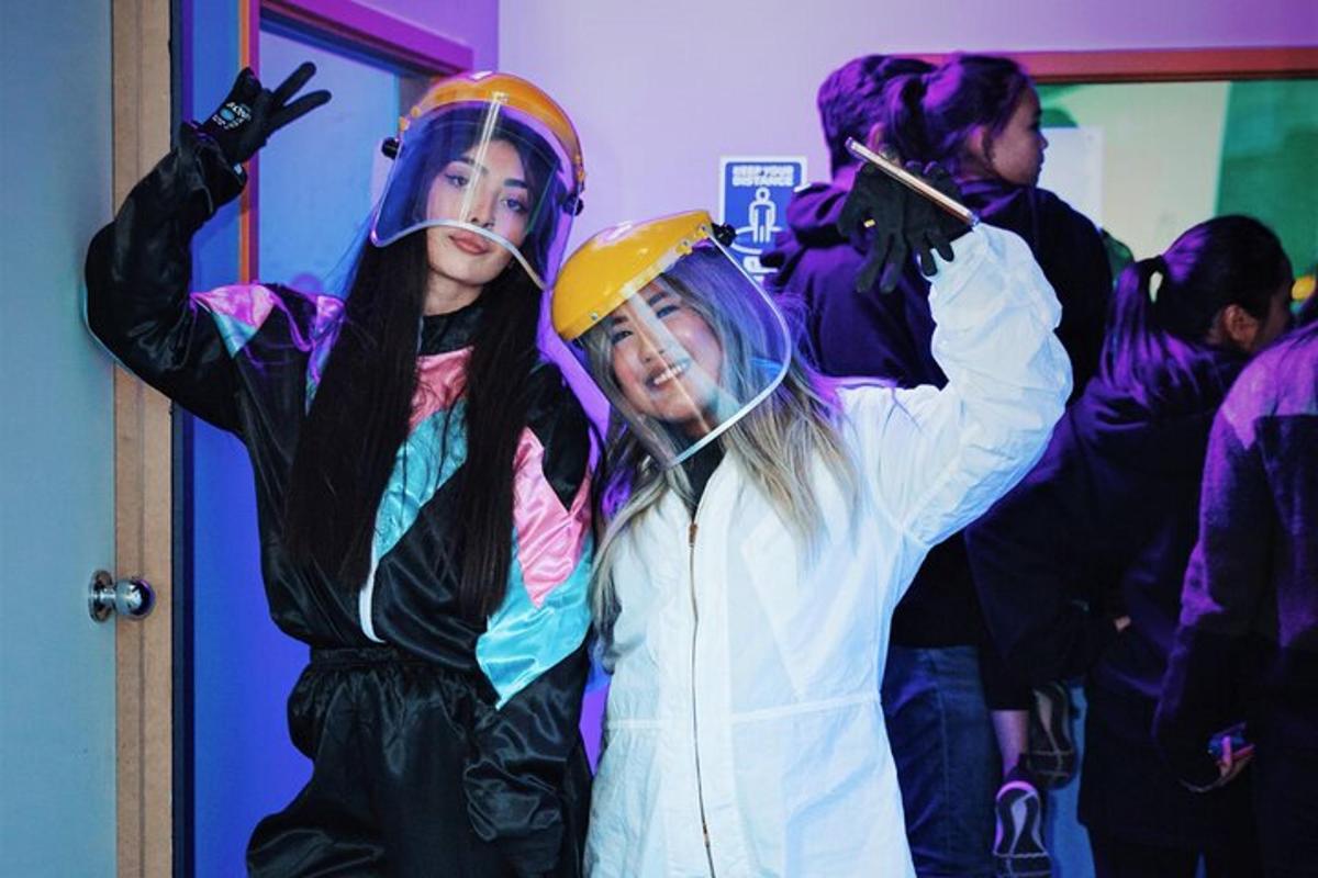 a group of people standing in a room wearing helmets