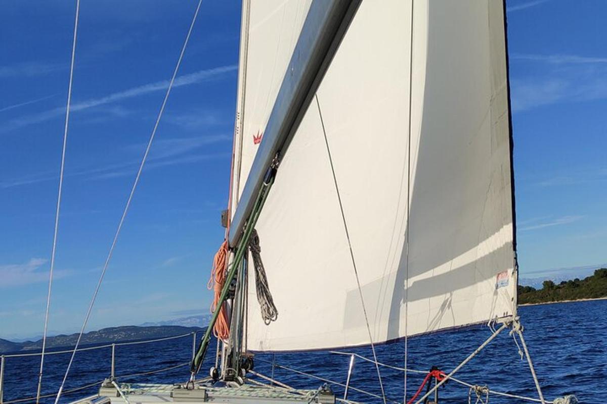 una vela bianca su una barca in acqua
