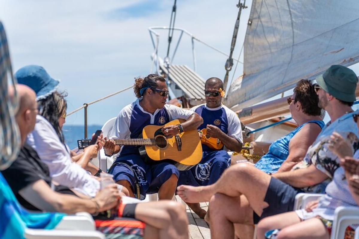 a group of people sitting on a boat playing guitar