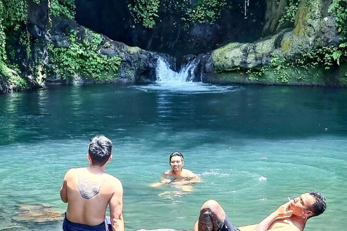 een groep mannen die zwemmen in een rivier met een waterval